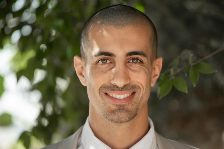 a smiling man wearing a tie and dress shirt