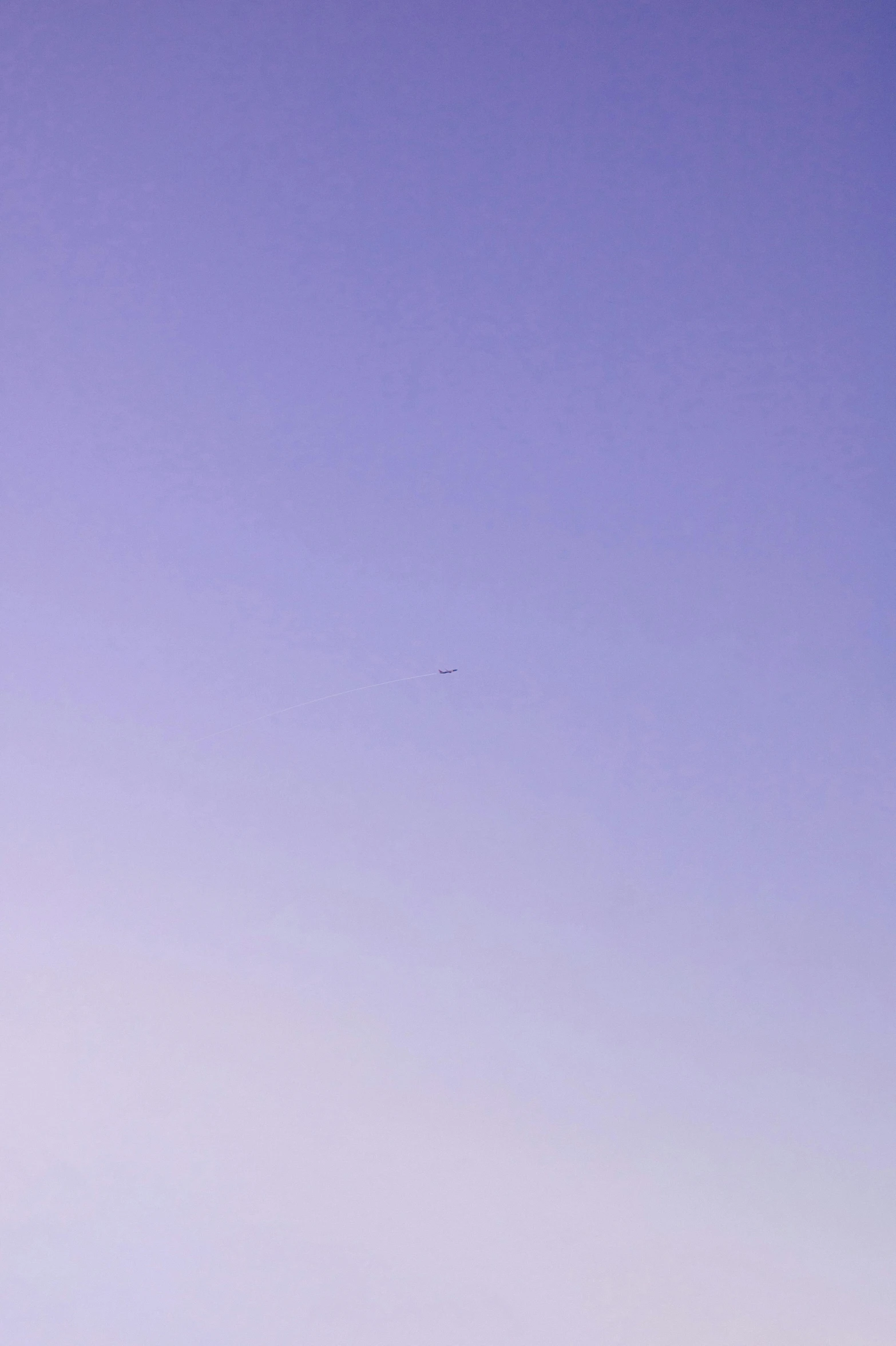 a person holding up a kite against a blue sky