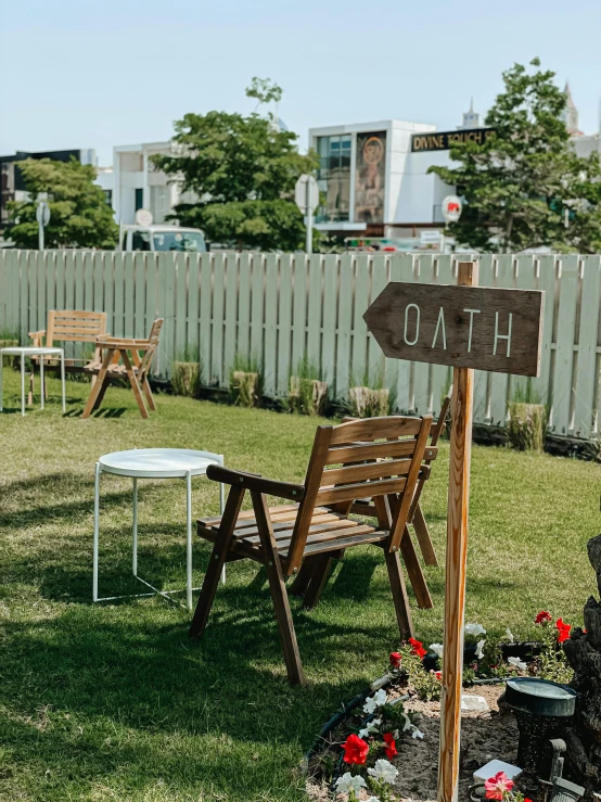 a wooden table sitting on the grass next to flowers