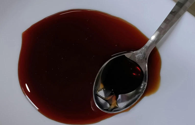 spoon covered with melted chocolate and some kind of sauce