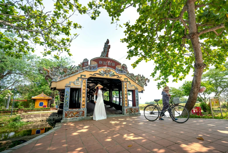 a bride and groom holding hands as they stand at a gazebo