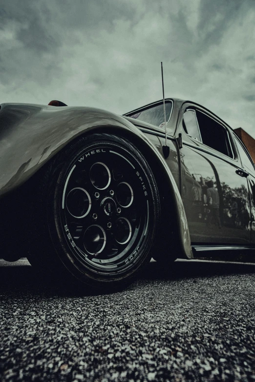 a very classic car sitting in a gravel road