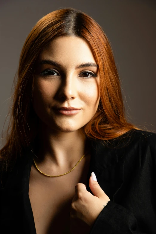 a woman with red hair wearing a golden chain necklace