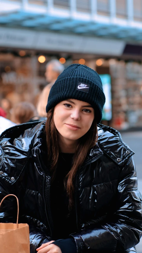 a woman sitting on a bench with a brown bag