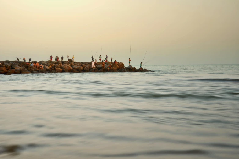 a bunch of people on the edge of the ocean