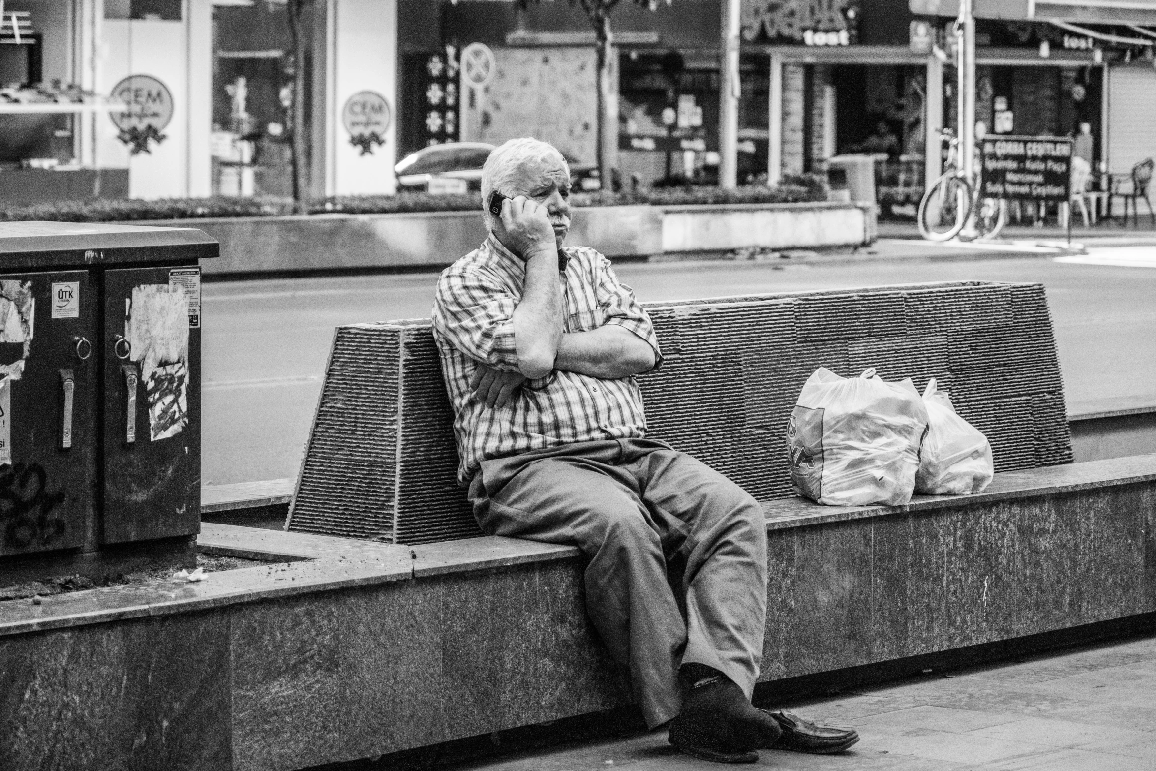 an old man sits alone in the city alone