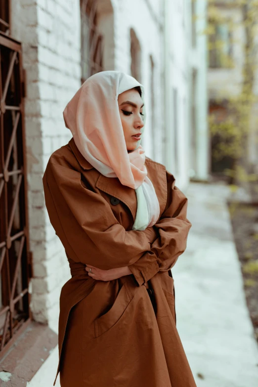 a young woman in a scarf and coat poses outdoors