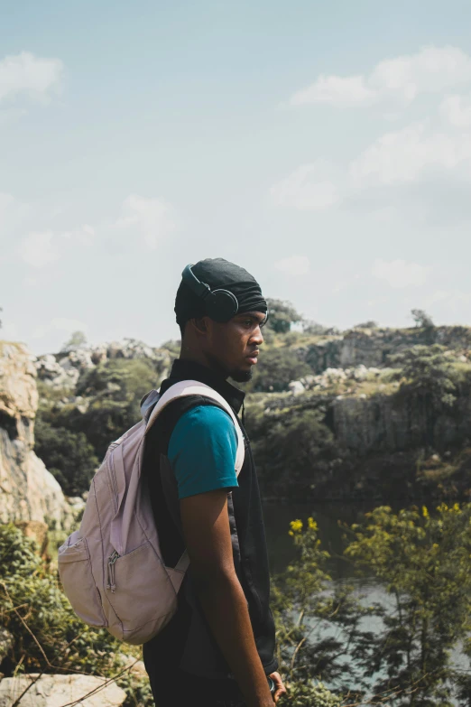 a man holding a backpack looking off into the distance