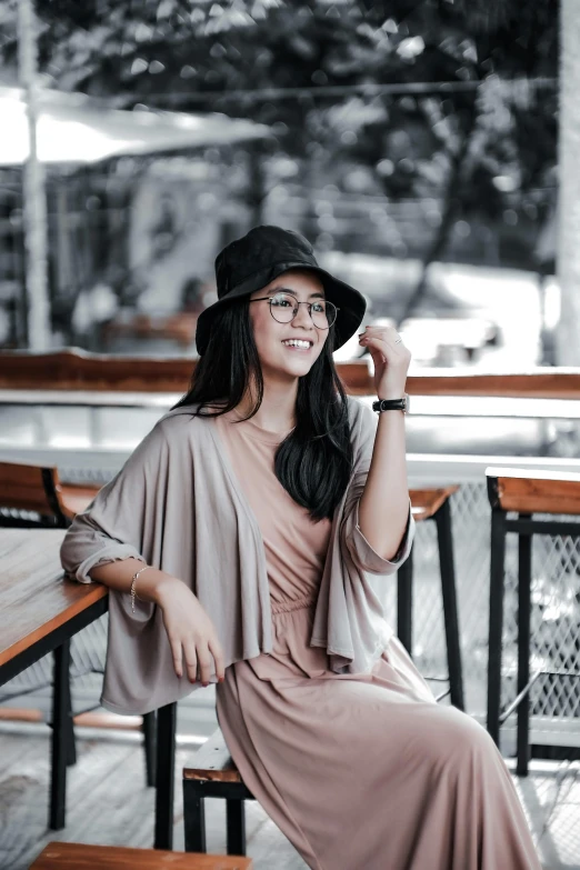 a woman in glasses, a pink dress and black hat