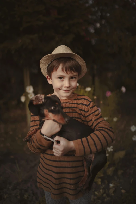 the boy is holding his small dog and smiling