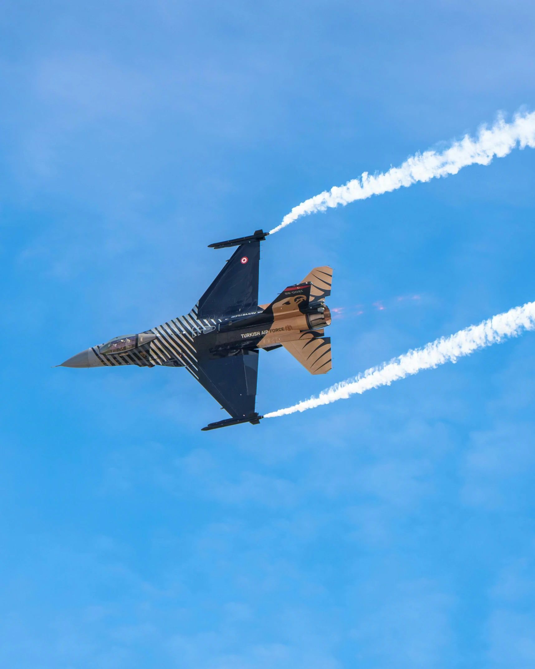 two jets flying next to each other in a blue sky