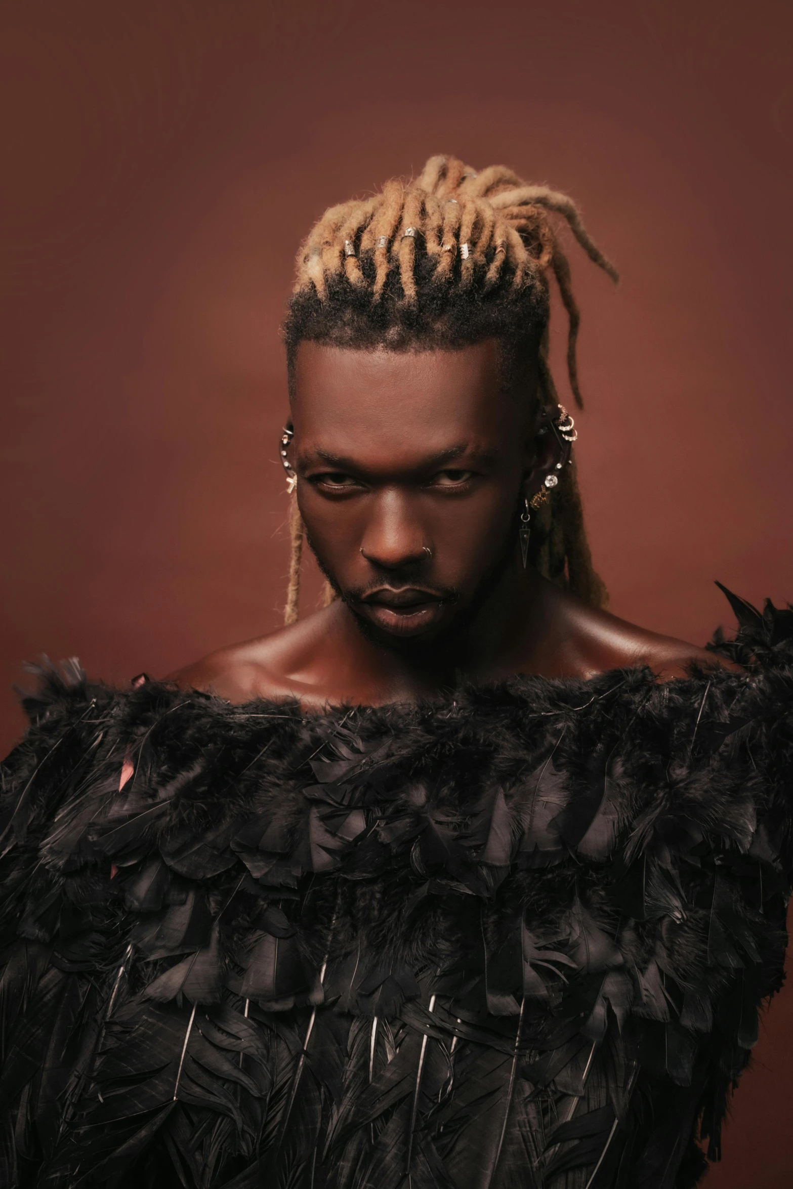 a young man in an extravagant dress and earrings