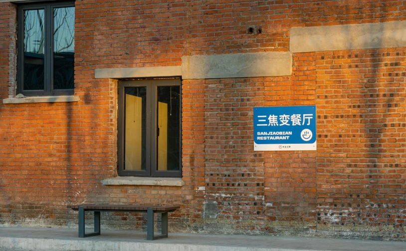 a wooden bench sitting in front of a brick wall