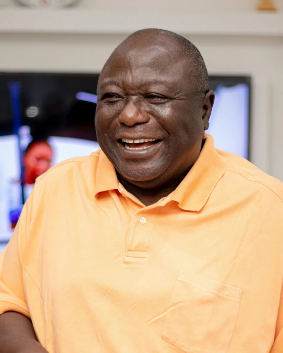 a man with his eyes closed and a bright orange shirt