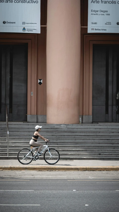 a woman riding her bike on the side of the street