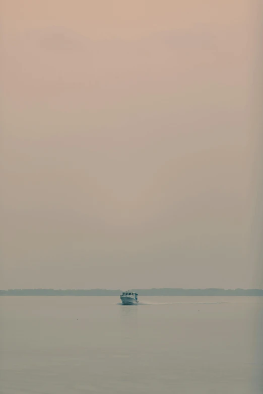 a small white boat on a big blue body of water