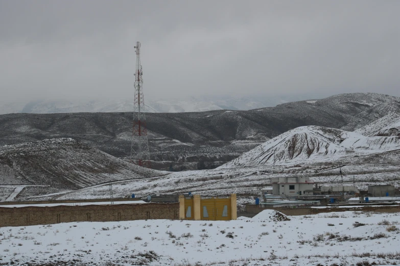 a mountain that is covered in snow near a tower