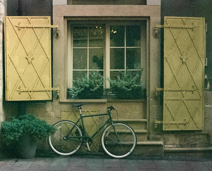 a bicycle is parked against the wall outside of a house