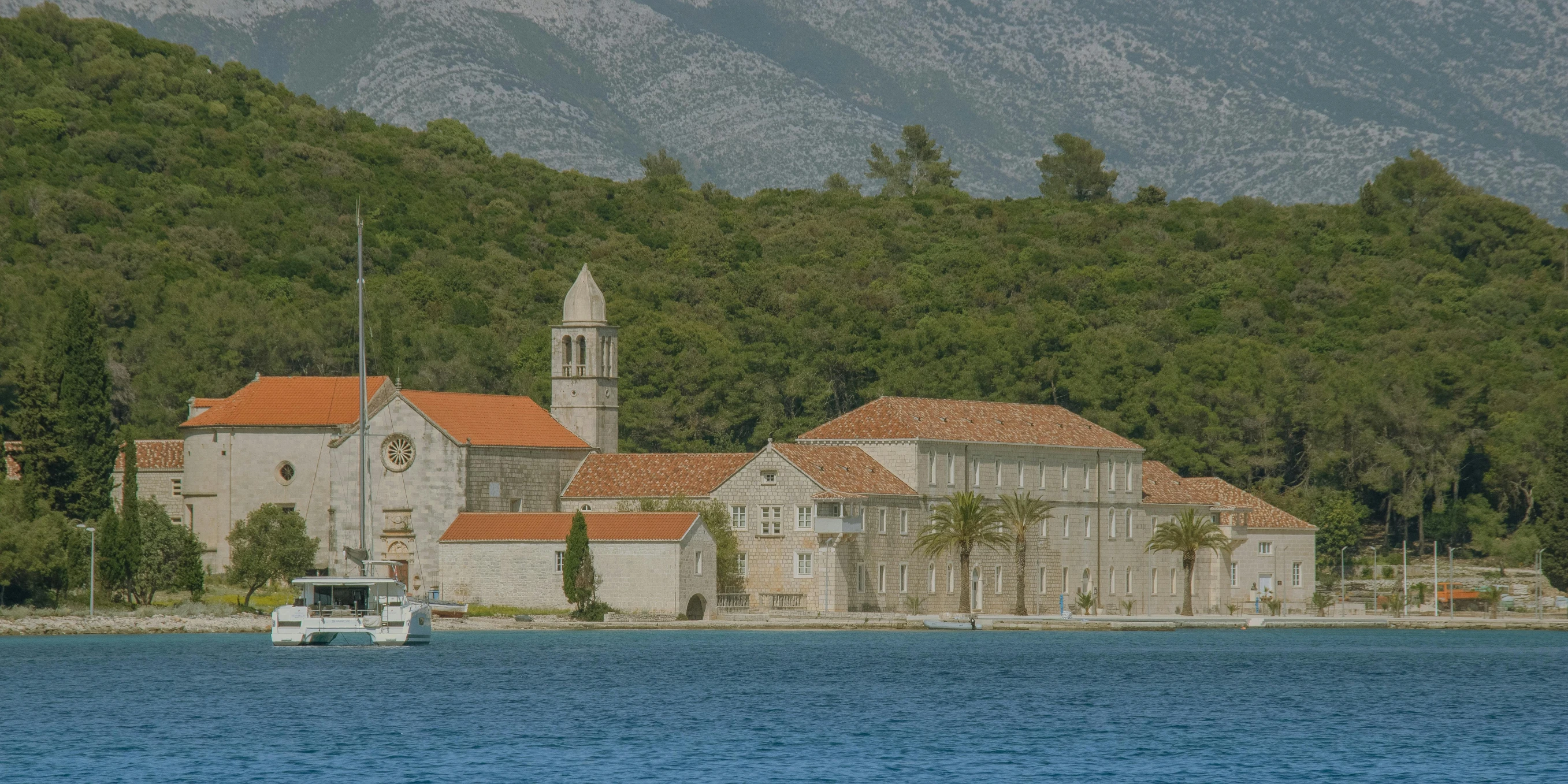 a body of water with a small boat in it near buildings and trees