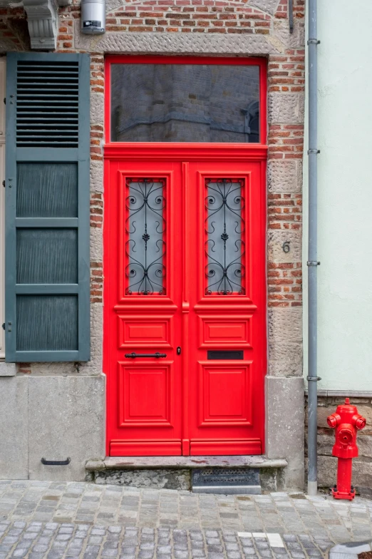 a red fire hydrant sitting next to a building