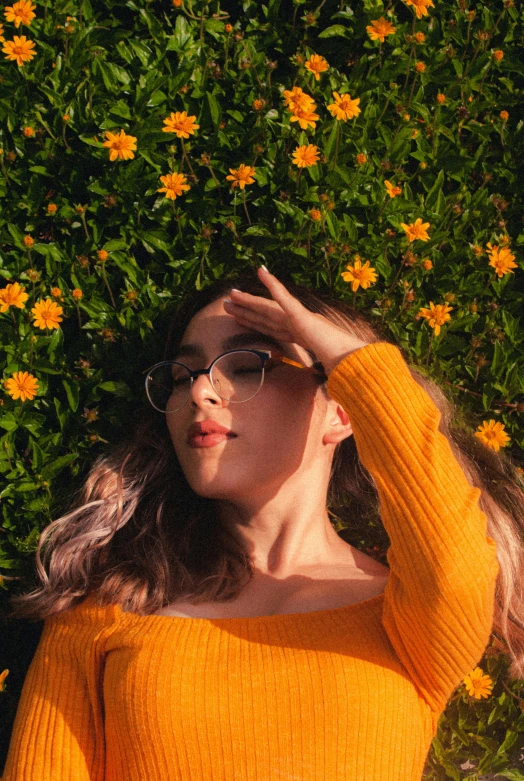 a woman is laying down in a flower field