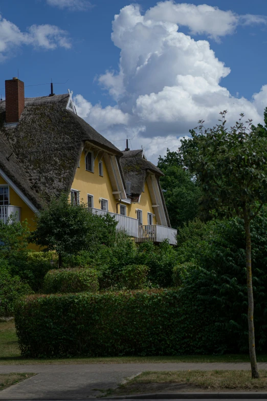 there is a yellow house with a thatched roof