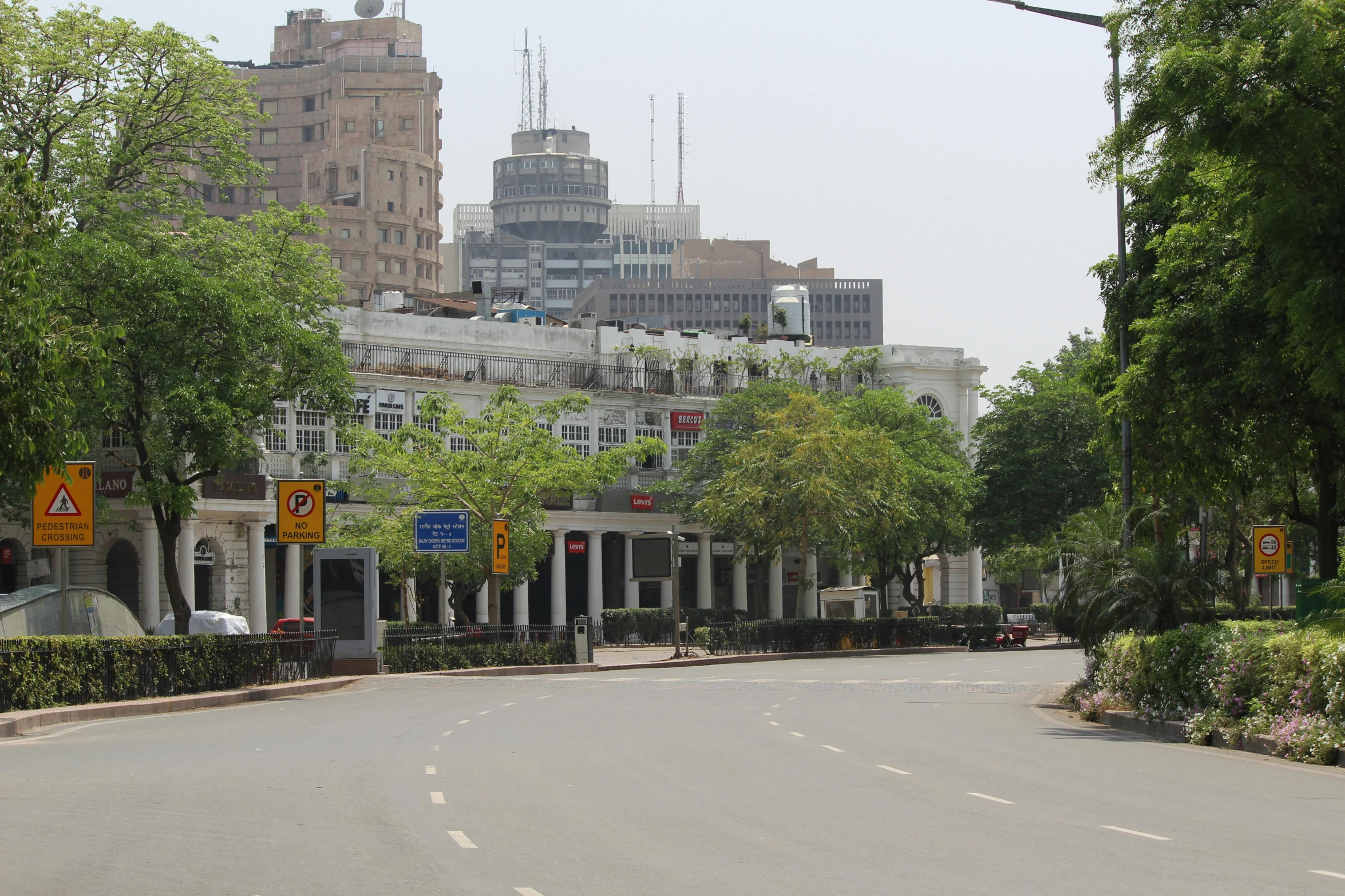 some large buildings some street signs trees and cars