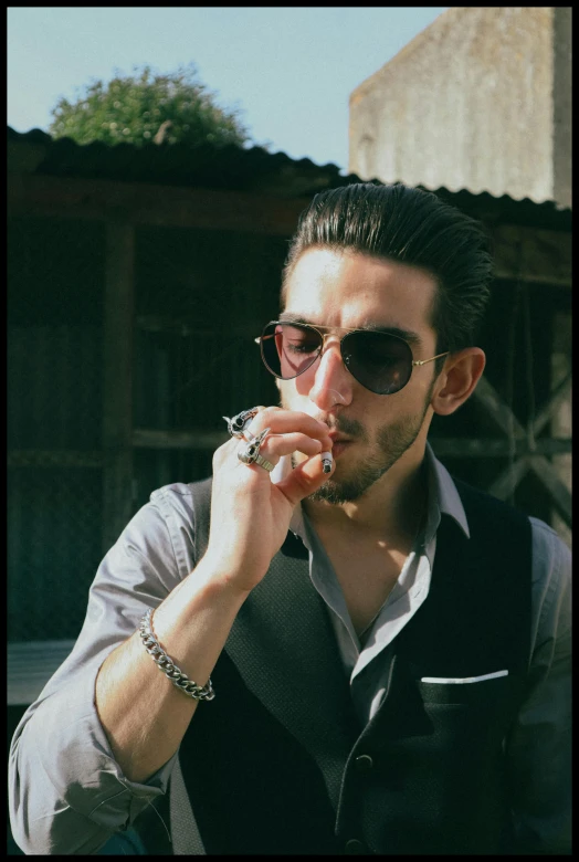 a man smoking soing while wearing sunglasses