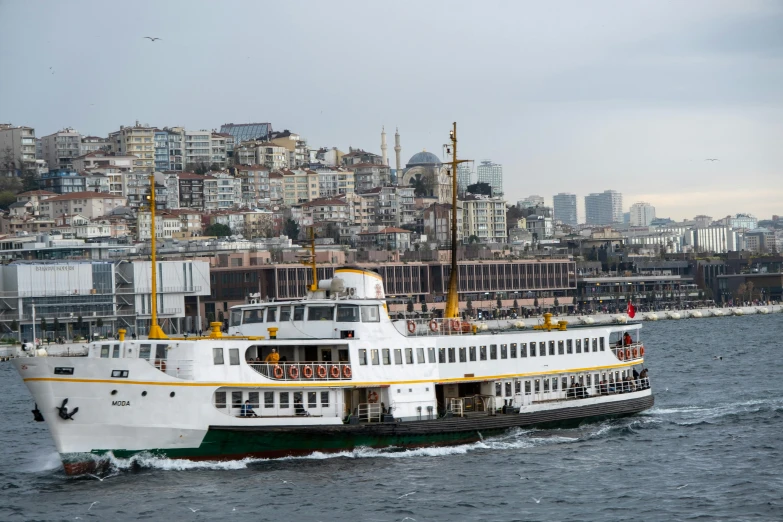 a large passenger ship floating in the ocean near buildings