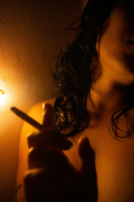 a person holding a cigarette in a dark room