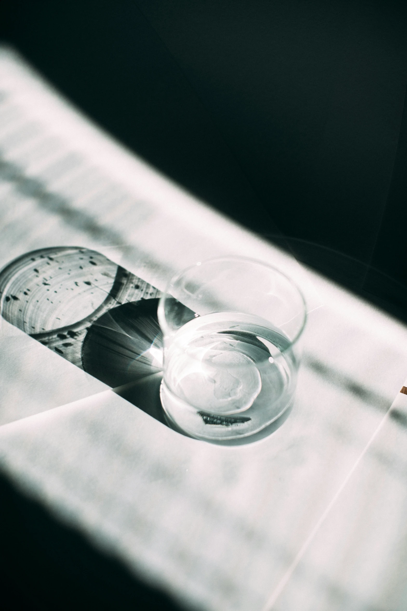 a glass cup with a spoon on it is next to another glass