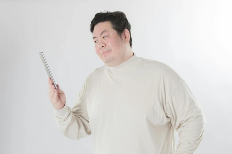 a chinese man standing up holding up a cell phone