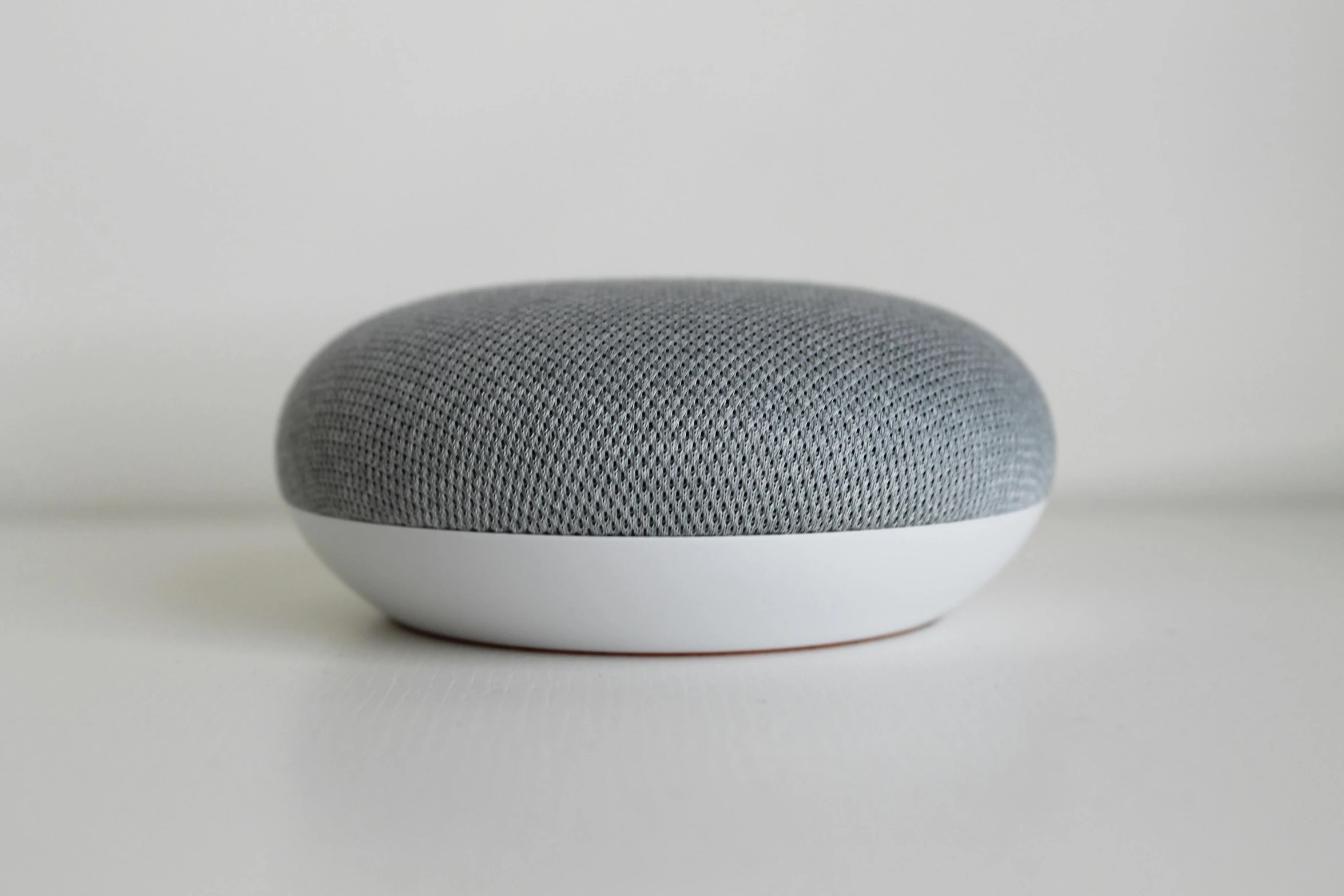 an google home mini speaker on top of the table