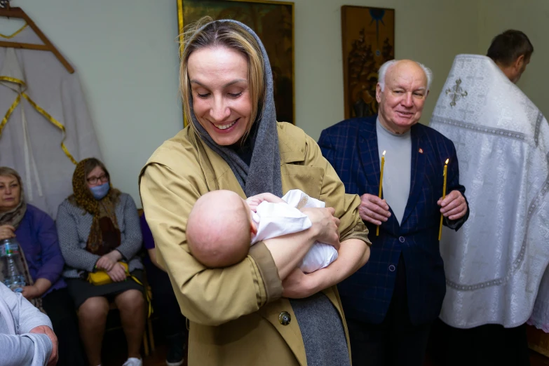 a woman holding a baby and smiling for a po