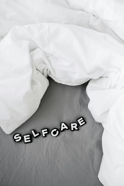 the word self care written on a pillow on a bed
