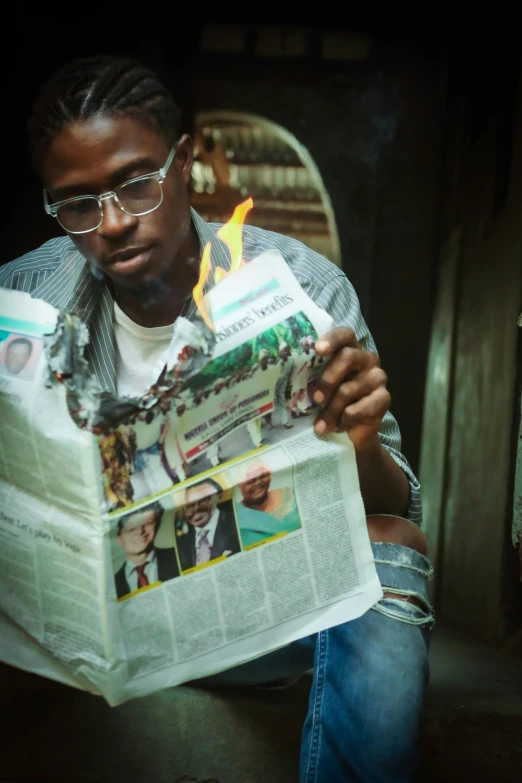a man with glasses reading a newspaper on his lap