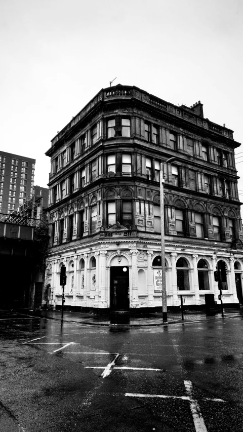 an old building with its lights on and a street in front