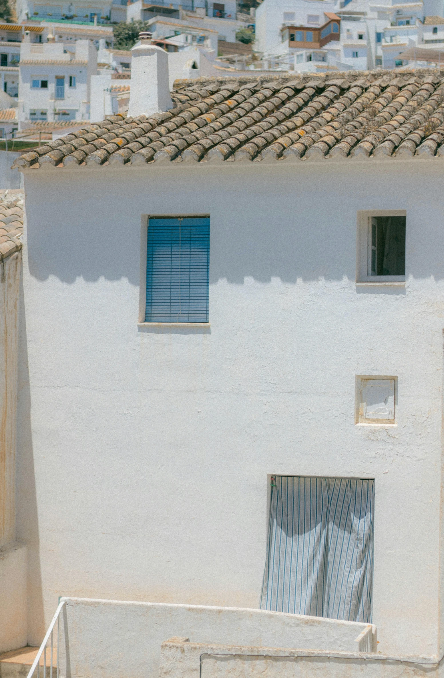 an adobe building with two windows and some small windows