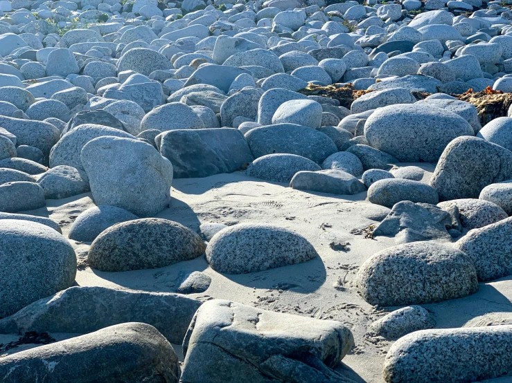 large rock formations sitting on top of a sandy beach