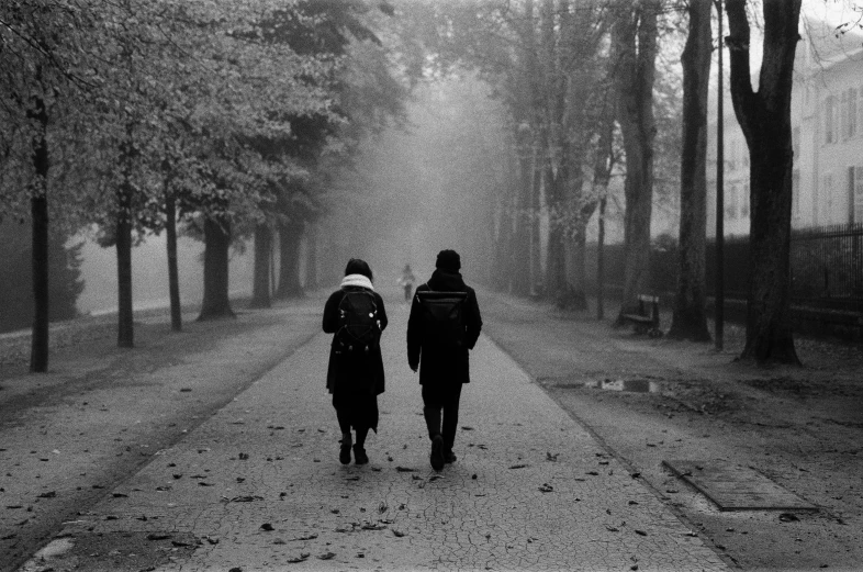 two people walking in the snow down a road