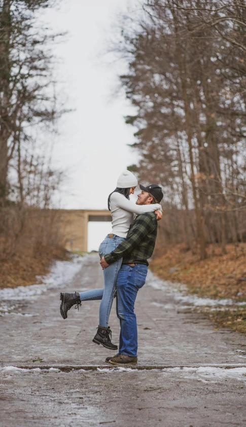 the couple hugging each other on a country road
