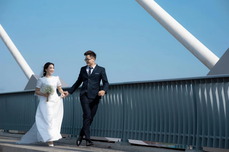 a bride and groom on the bridge during their wedding day