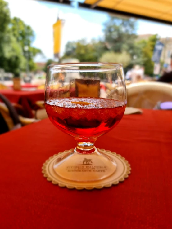 a glass with some water sitting on top of a table