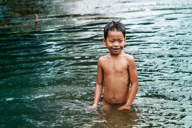 a little boy in the water is swimming