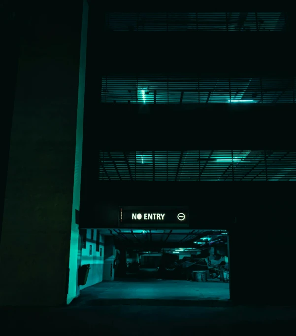 a parking garage is open at night with no entry signs