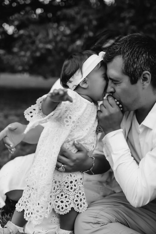 a black and white po of an older man kissing his baby