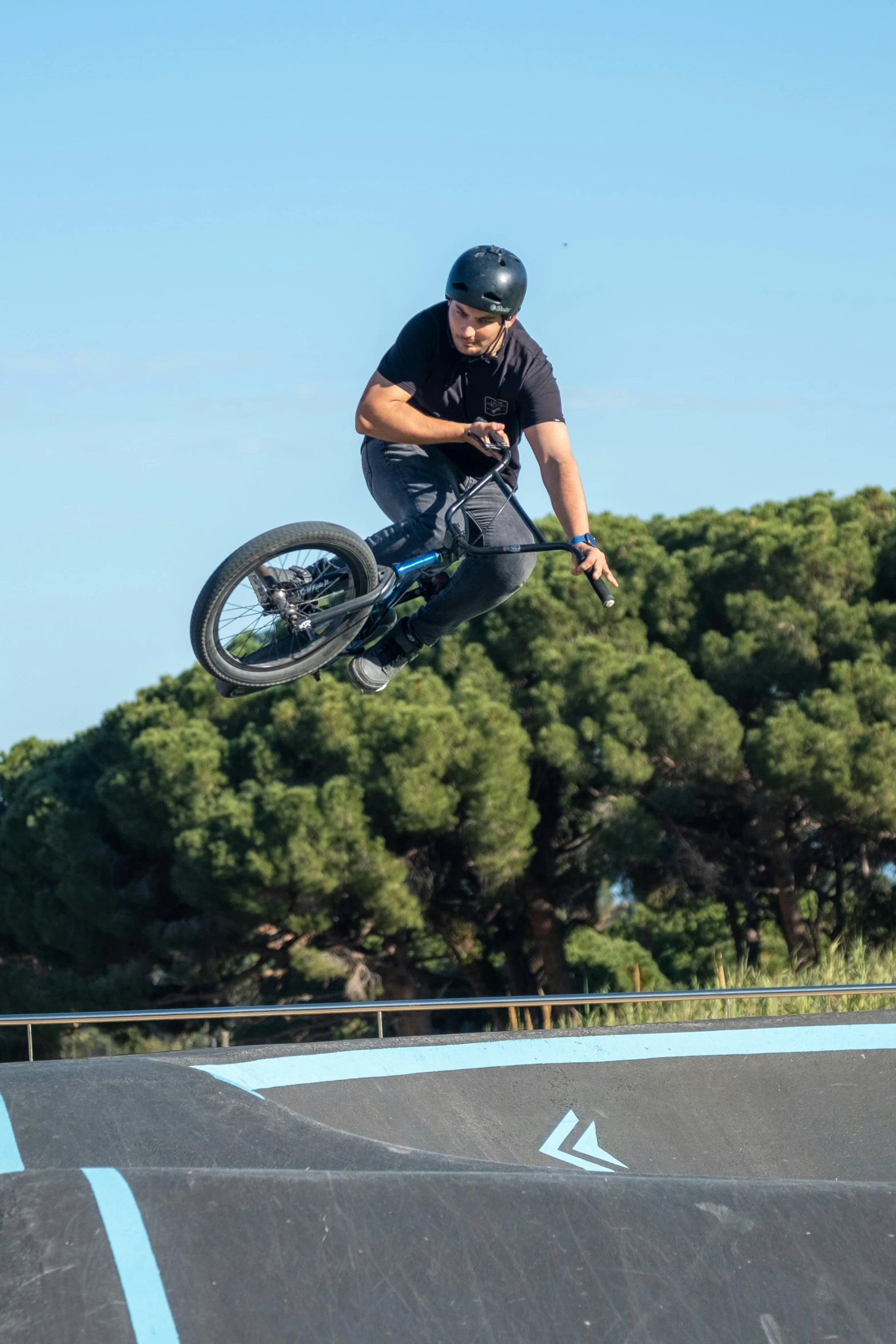 a man jumping his bike in the air at a skate park