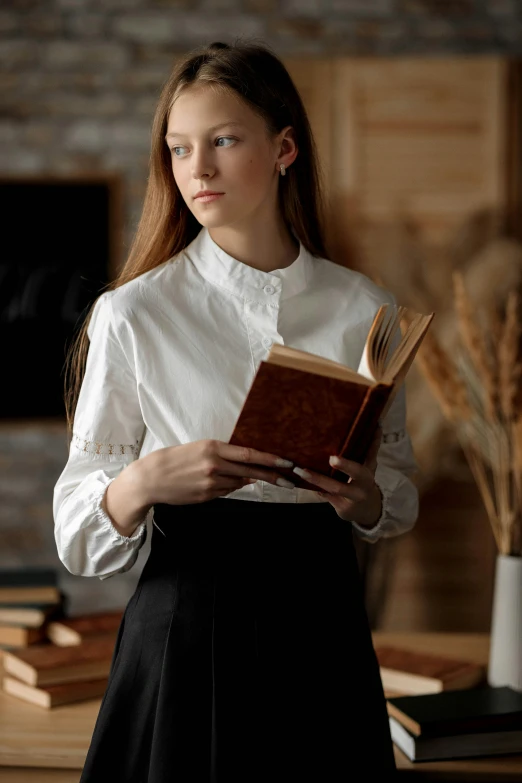 a woman in a dress and shirt is reading a book