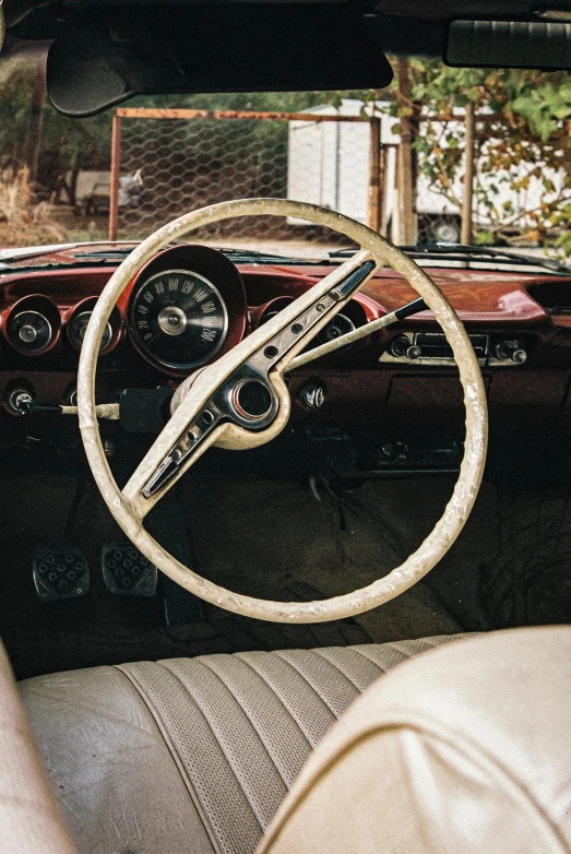 the inside of an old car with steering wheel and dashboard