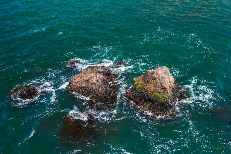 two large rocks sitting in the middle of the ocean